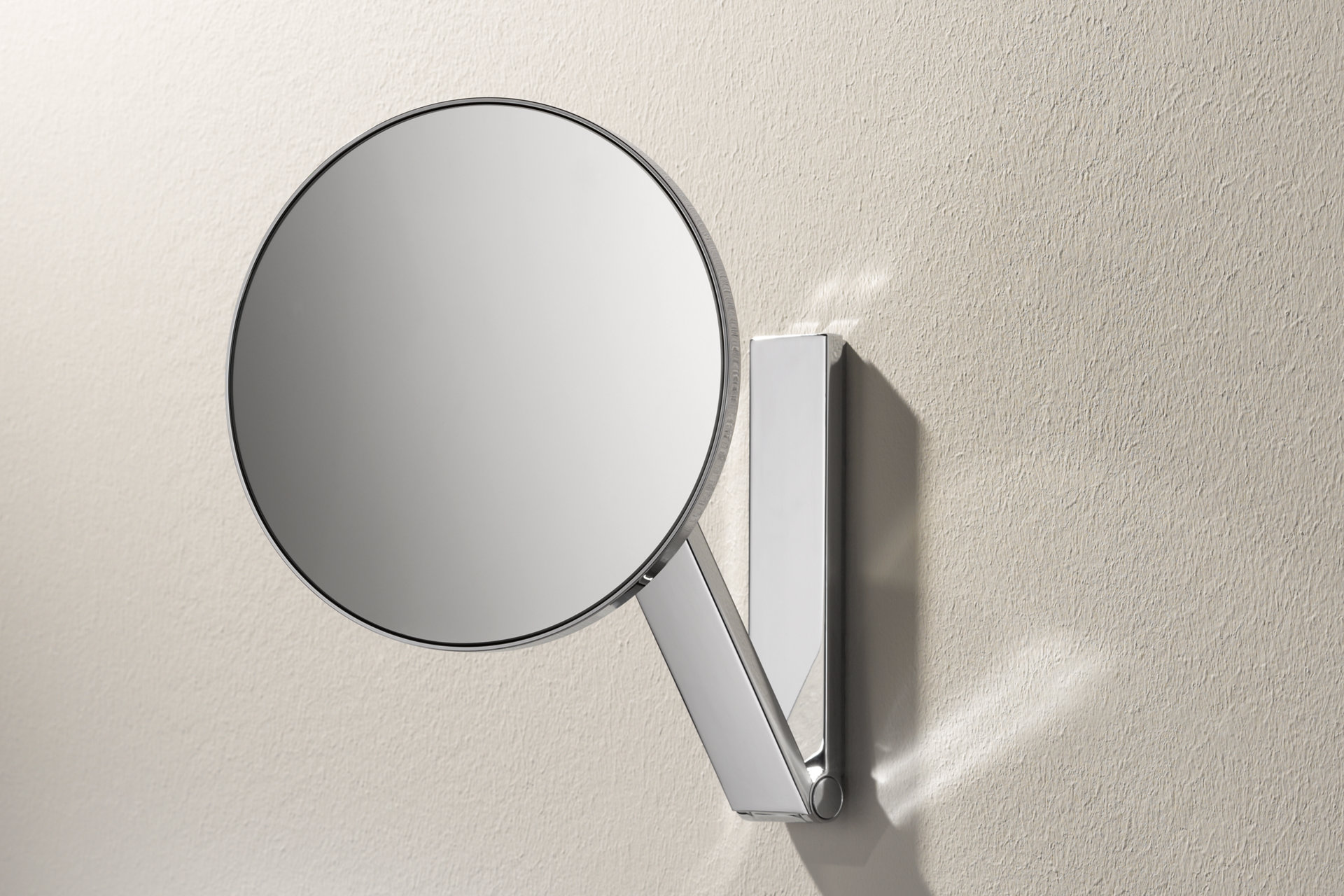 The unlit, round iLook_move cosmetic mirror is mounted on the wall