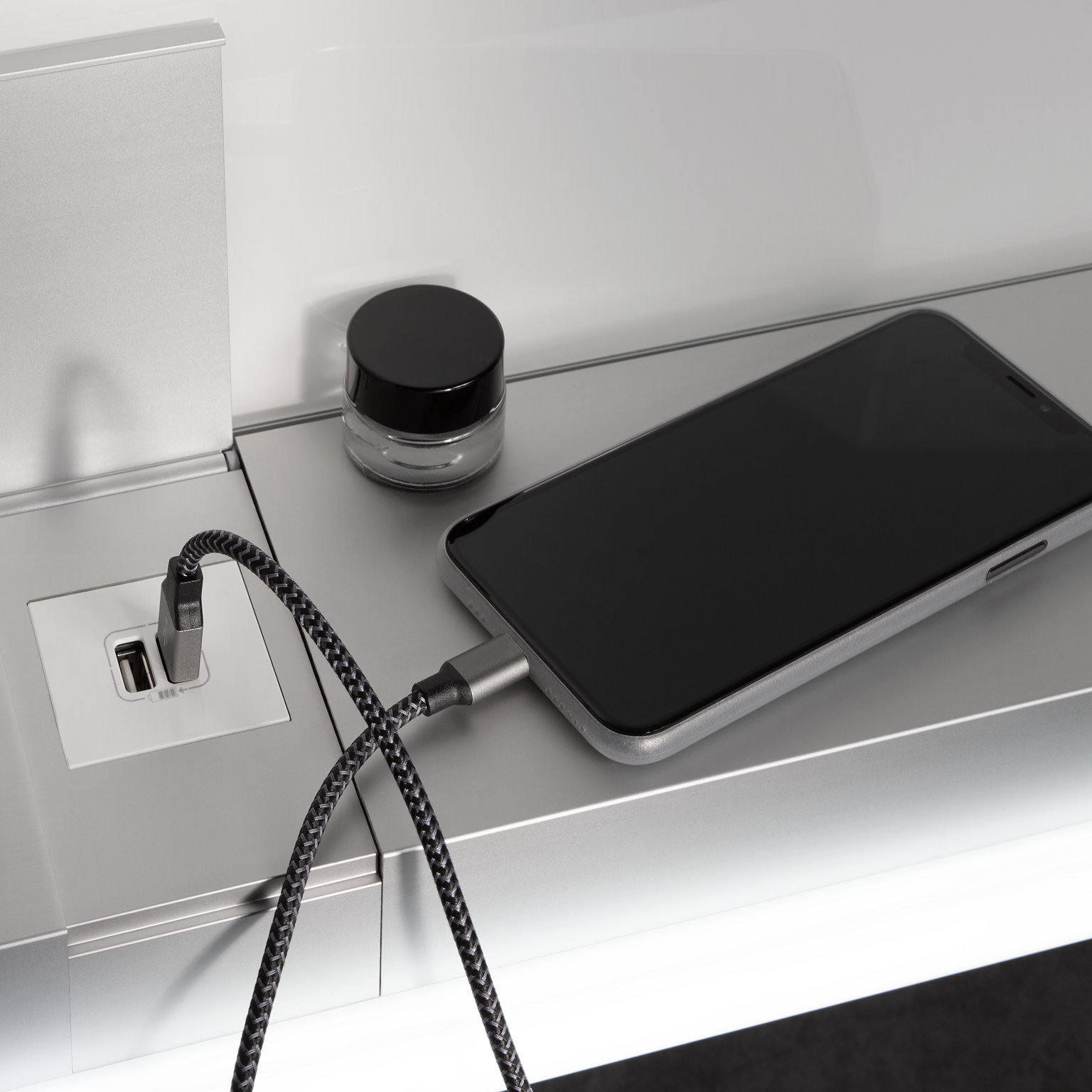 Handy mit Ladekabel eingesteckt in USB-Ladestelle im Royal Modular 2.0 Spiegelschrank