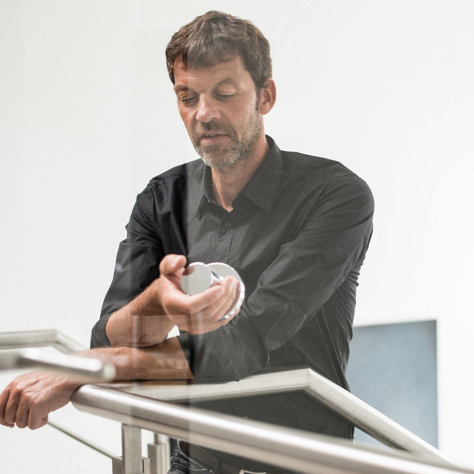 Dominik Tesseraux steht an einem Geländer und hält ein IXMO Element in der Hand