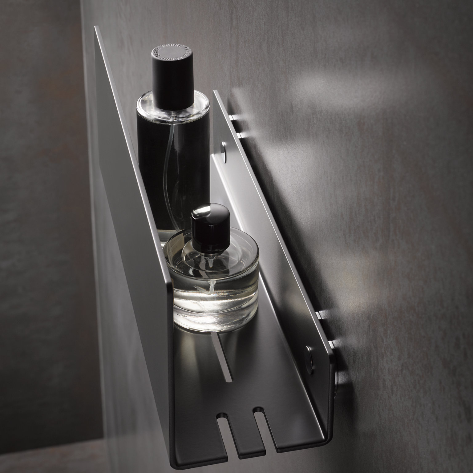 Vue de dessus d’une tablette de douche en noir mat avec des récipients de produits de soins corporels