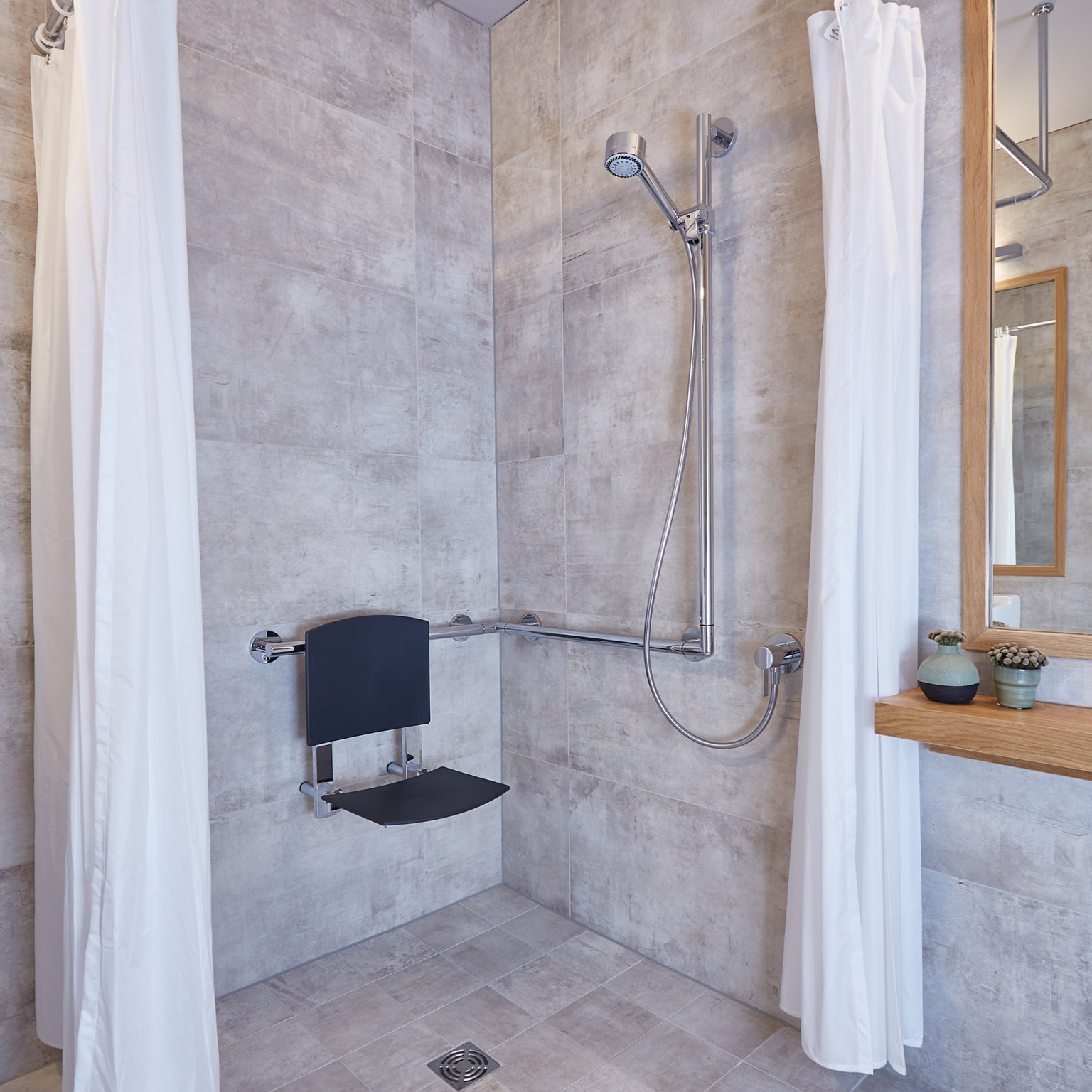 Dusche mit KEUCO Relingsystem und Duschsitz im Hotel Arcadeon
