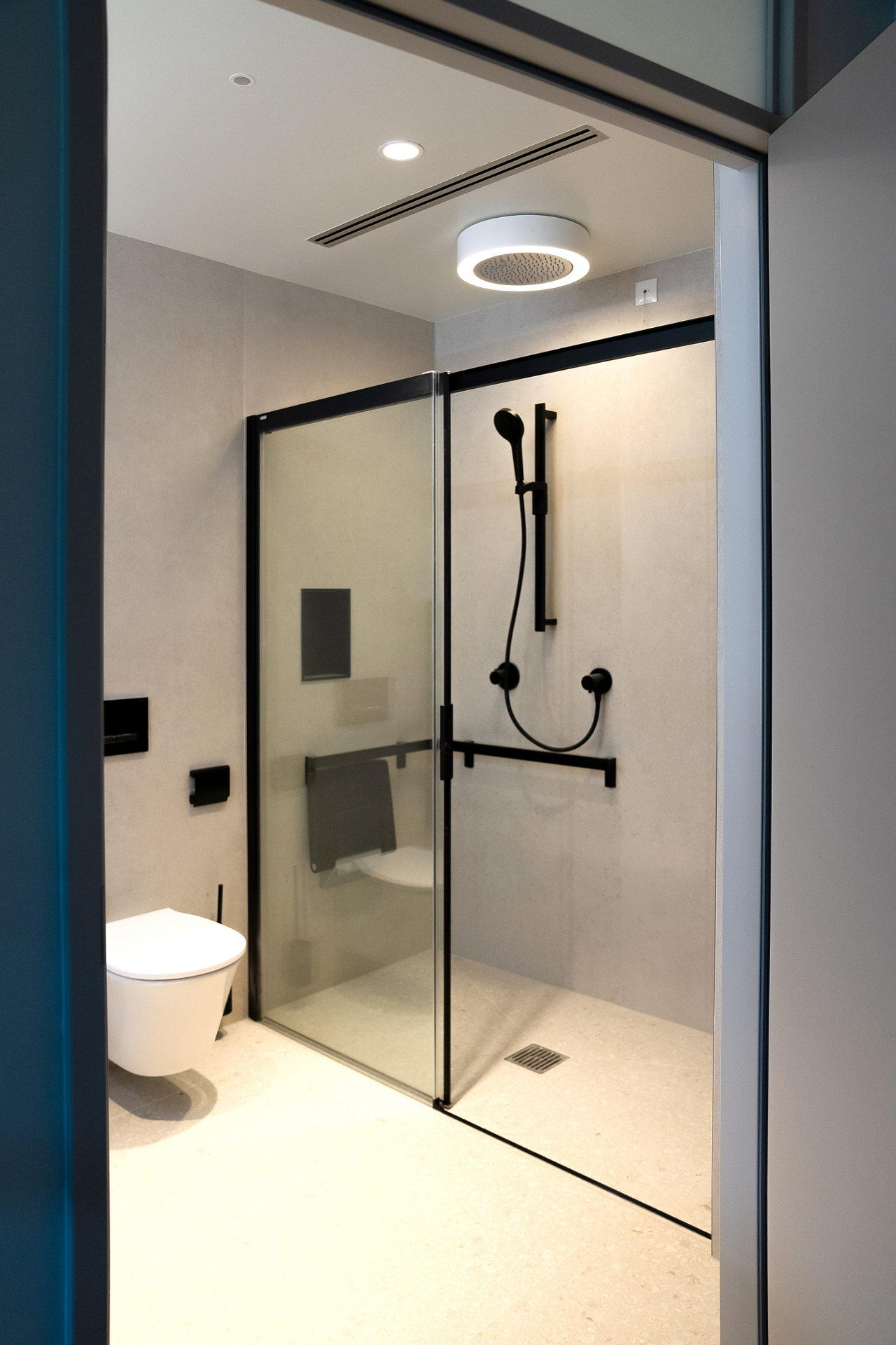 Klinikum Garmisch-Partenkirchen Badezimmer Dusche mit IXMO Armaturen, AXESS Relingsystem und PLAN Duschsitz in Schwarz matt und Duschleuchte