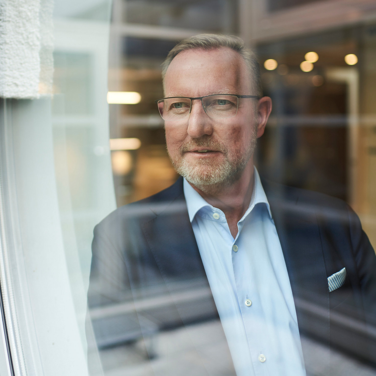Portrait Lubert Winnecken lächelnd aus einem Fenster schauend