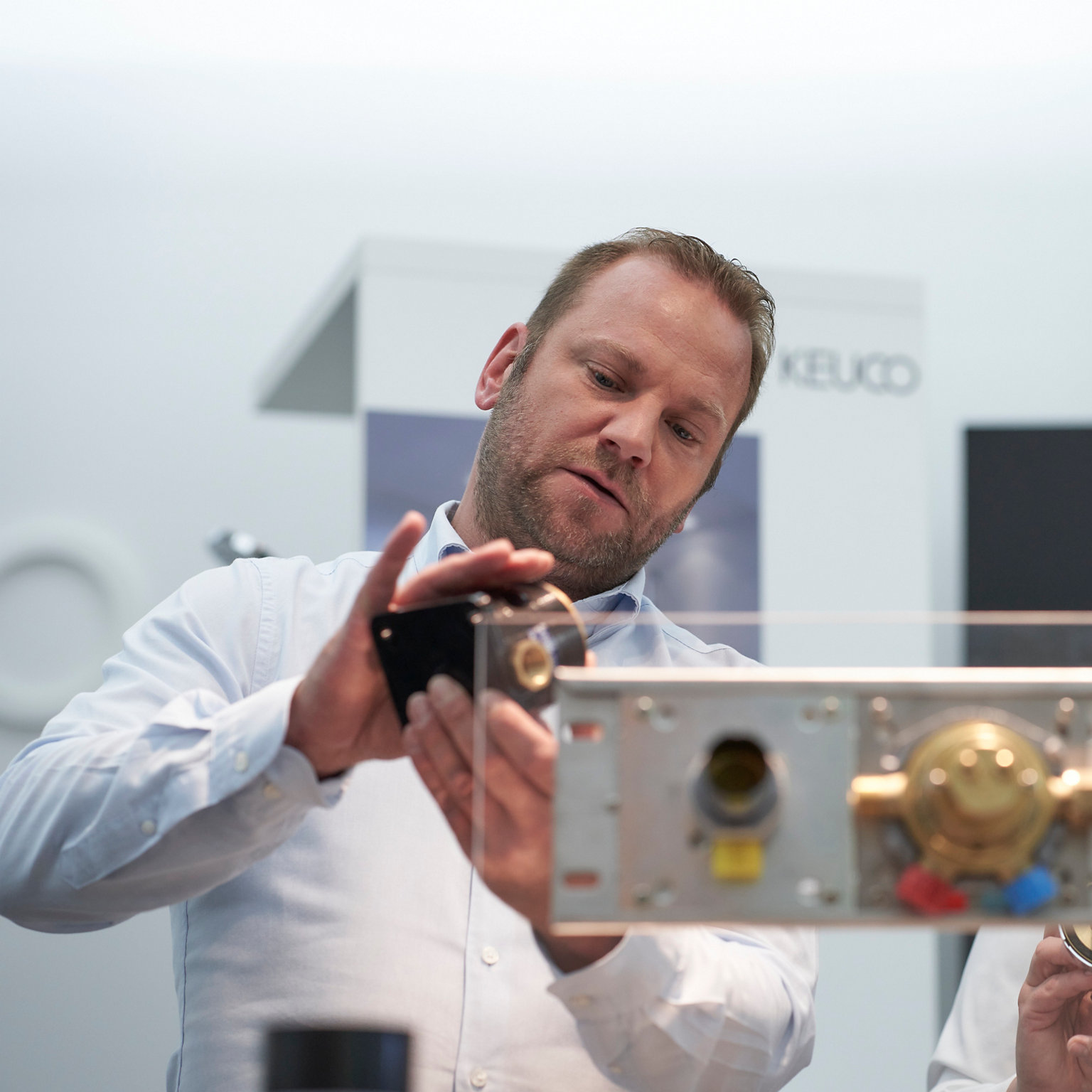 Hinter der IXMO Montageschiene begutachten zwei Personen ein IXMO Element