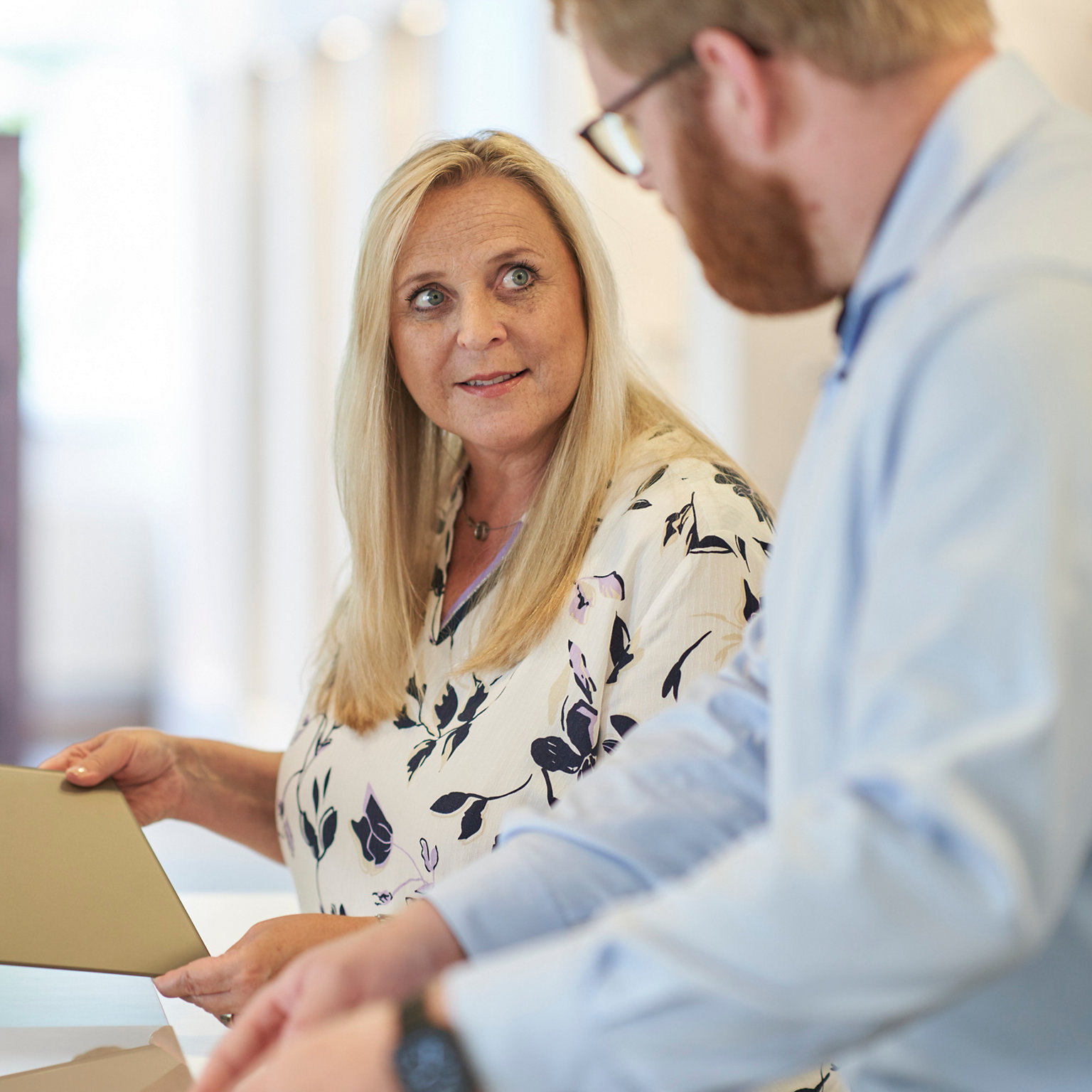 Frau diskutiert eine Materialoberfläche mit ihrem Gesprächspartner