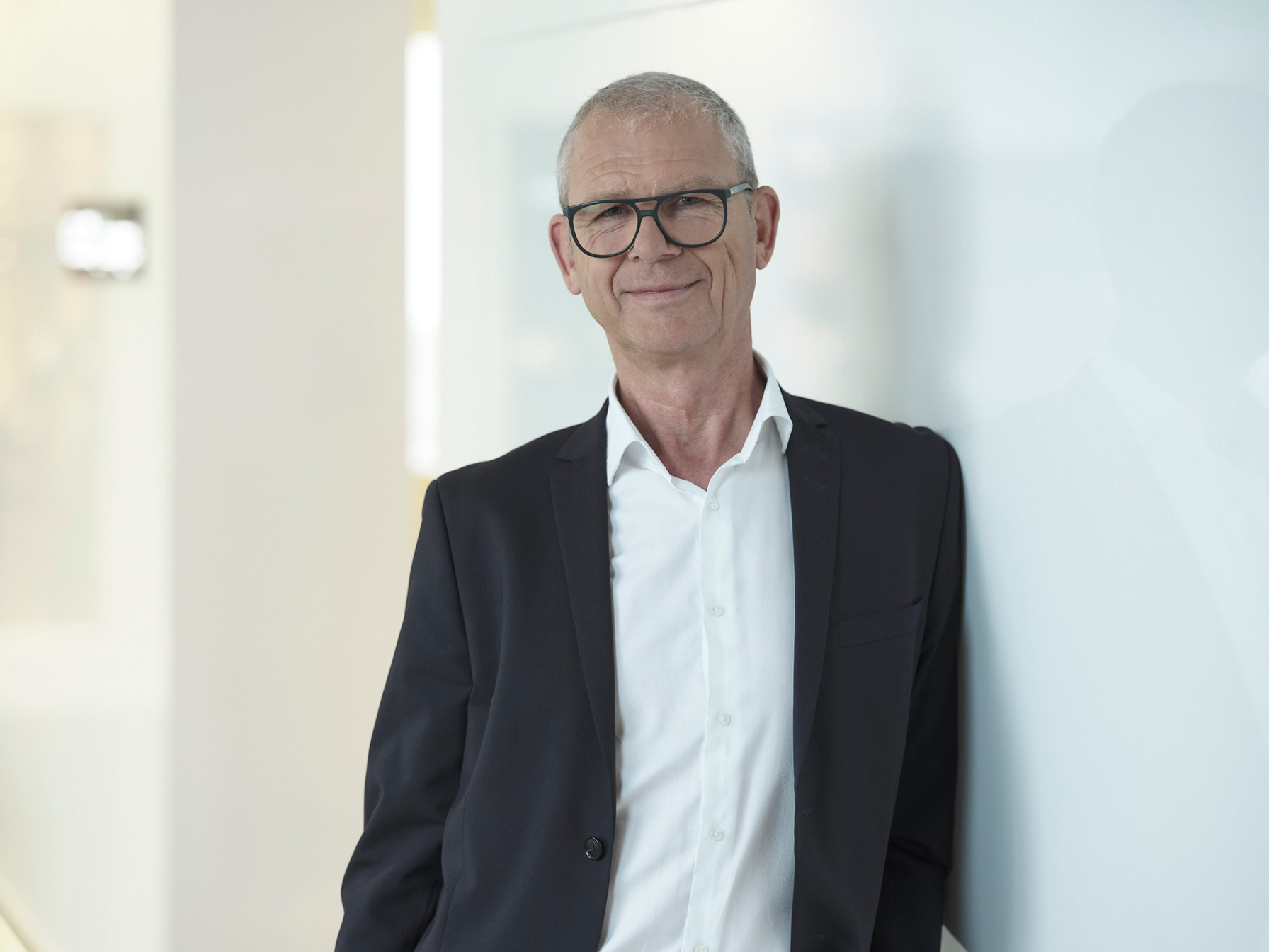 Portrait Andreas Lohmann nah an Wand gelehnt