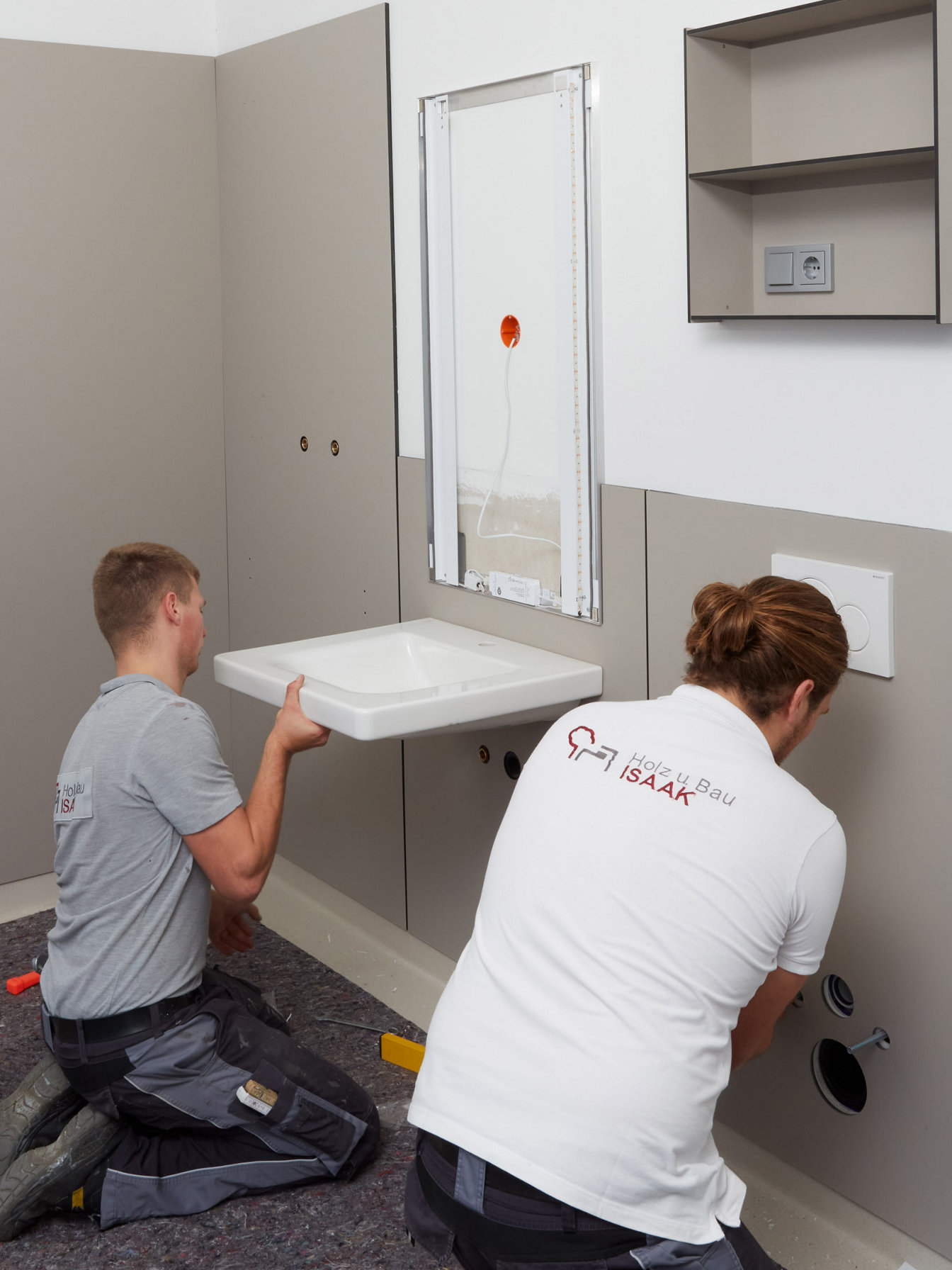 Handwerker montieren einen Waschtisch in einer systemischen Badlösung