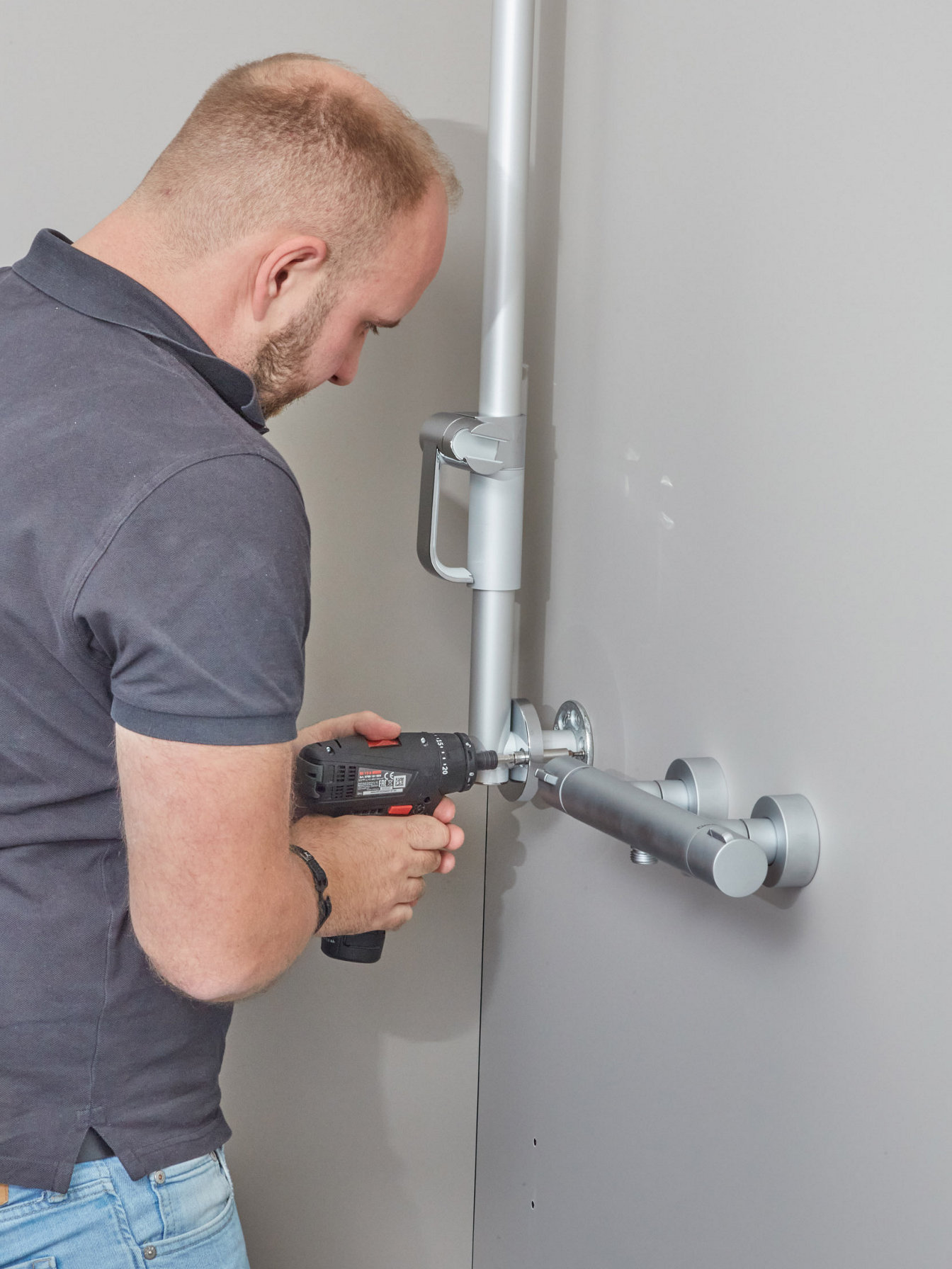 Handwerker installiert eine Duschstange im systemischen Bad
