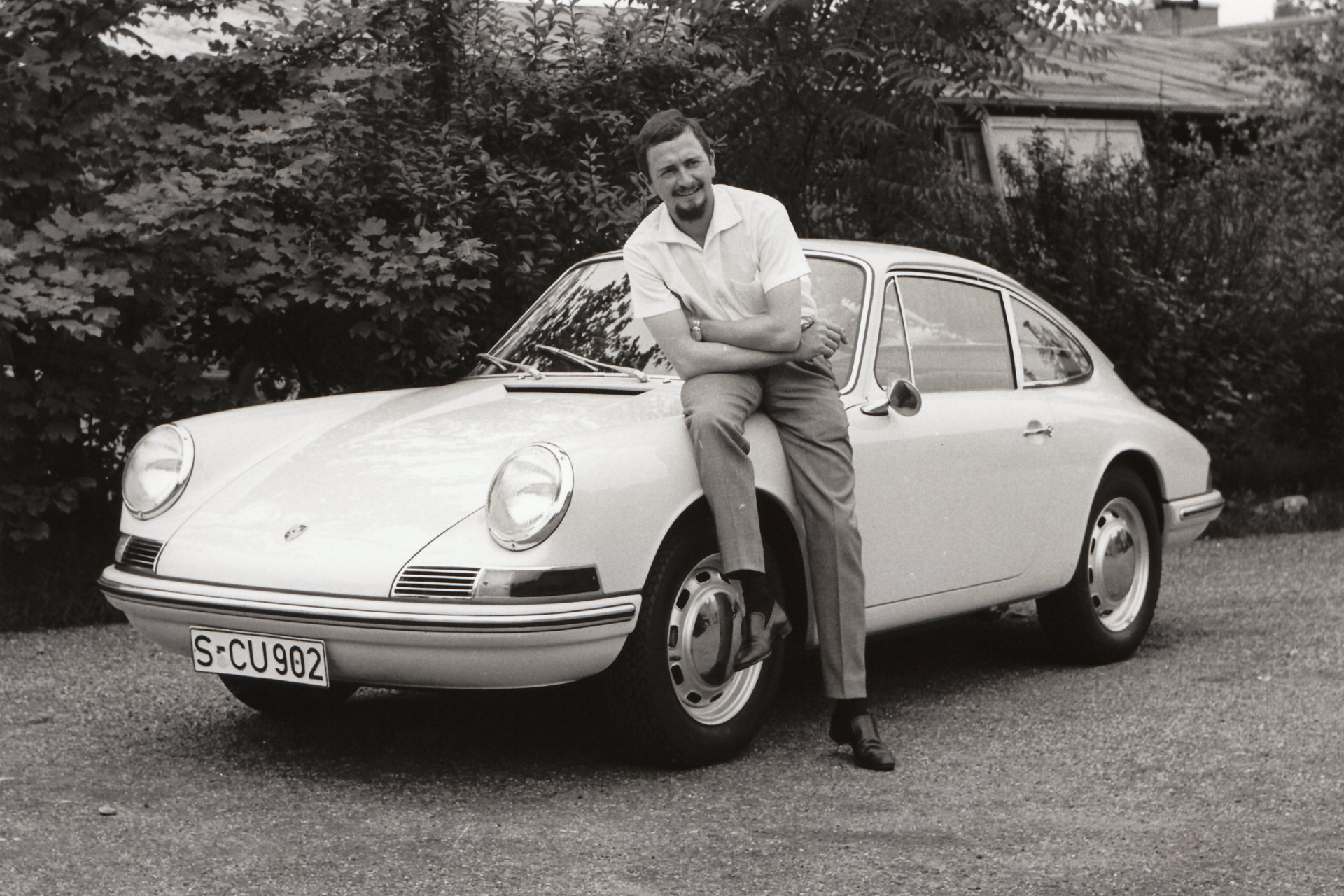 Mann lehnt an Porsche