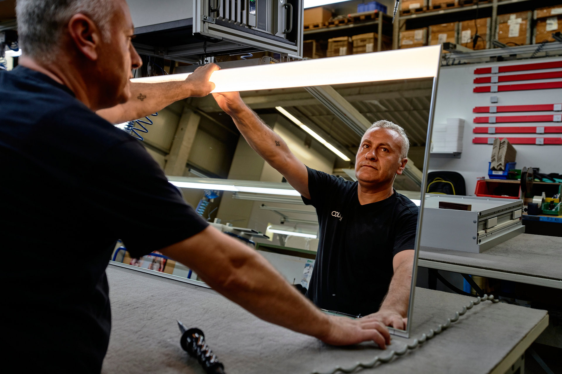 in den EDITON 400 Lichtspiegel, den er vor sich aufgerichtet hält