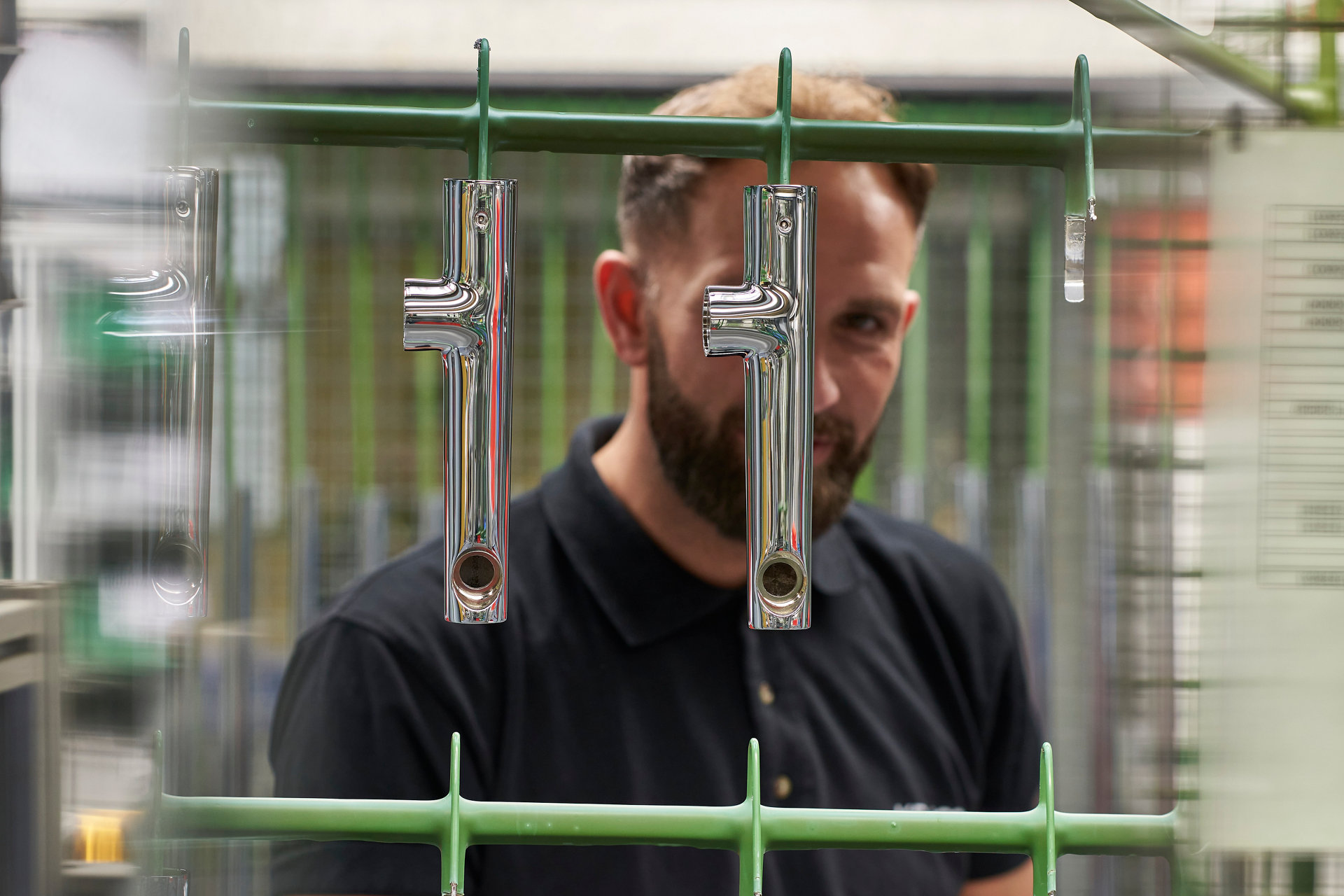 Mitarbeiter putzt Armaturen nach dem Galvanikbad