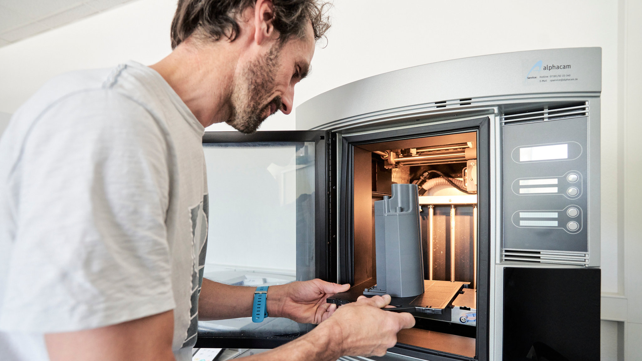 Mitarbeiter nimmt das Modell aus dem 3D-Drucker