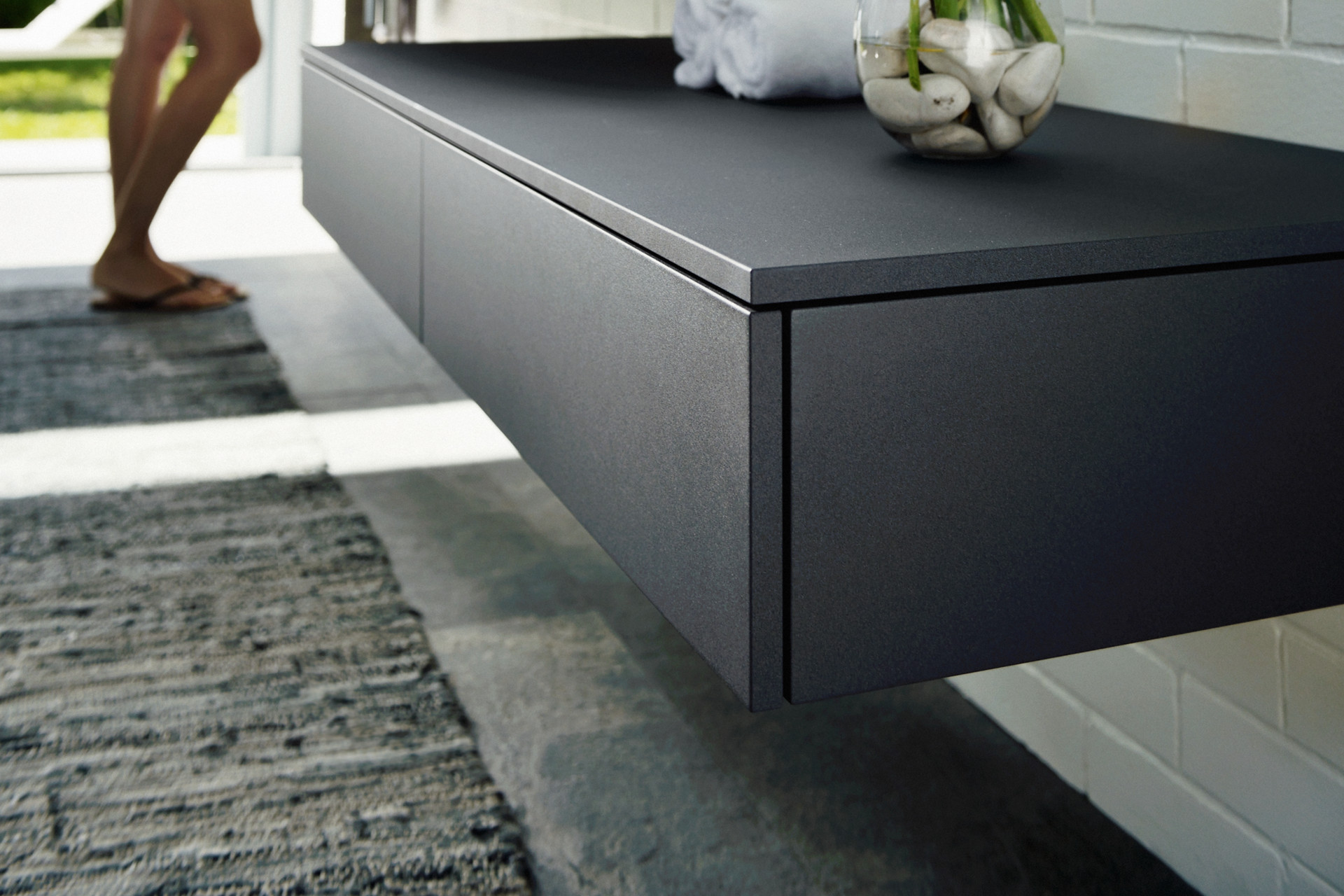 Frau am Waschplatz mit Sideboard der Edition 400 in Anthrazit im Vordergrund 